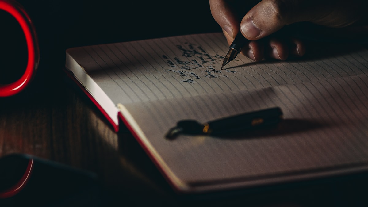 Main prenant des notes sur une feuille lors d’une étude