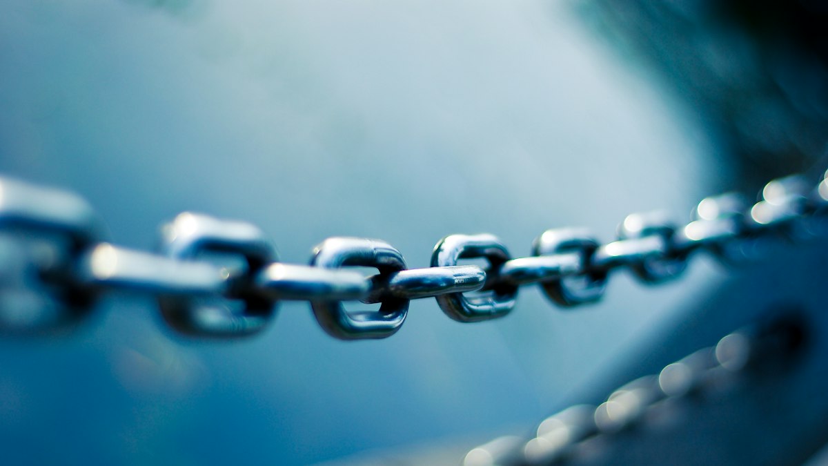Maillons d'une chaîne en acier sur fond bleu, symbole des liens entre sites